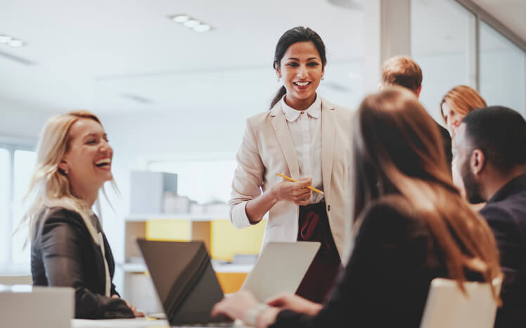 Women in corporate office discussing work.