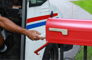 Mailman dropping letter into box_change your address USPS