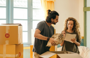 A couple looking at a list while packing boxes.