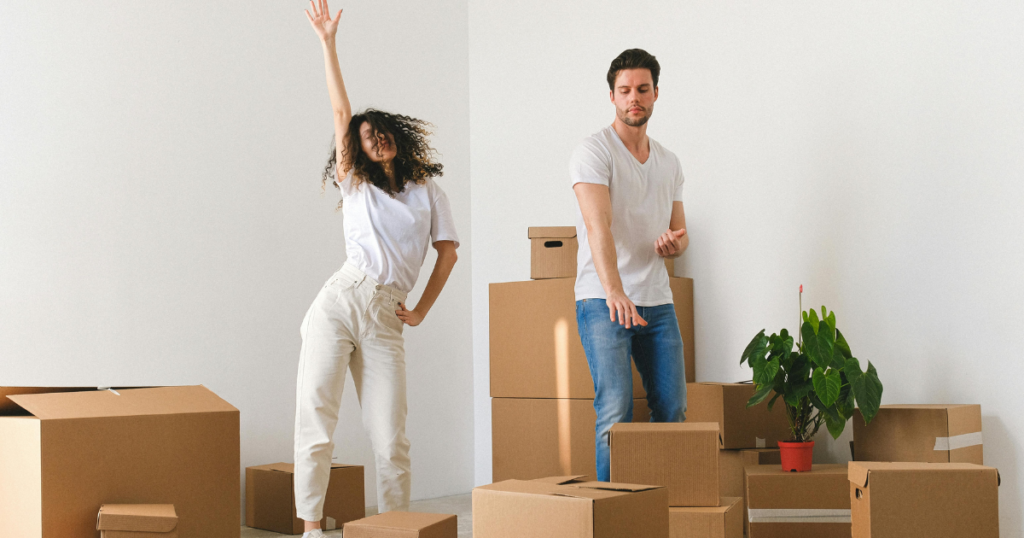 Couple dancing around moving boxes