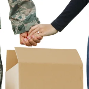 Military couple holding hands by a moving box.